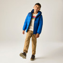 Full-length lifestyle image of the junior insulated hooded jacket, highlighting the quilted design, padded hood, lightweight warmth, and casual outdoor styling.