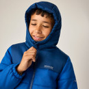 Close-up lifestyle image of the junior insulated hooded jacket with the hood up, showcasing the insulated hood, high collar, full-zip fastening, and quilted design.