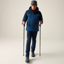 Full-length view of a model wearing the Regatta Highton Stretch Padded men's waterproof jacket in Blue/Navy with walking poles.