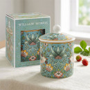 William Morris Strawberry Thief fine china storage canister with a matching lid, featuring the iconic bird, strawberry and floral pattern on a soft blue background with a gold-effect rim. Displayed beside its matching gift box on a linen-covered table with fresh strawberries.