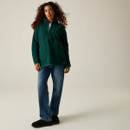 Full-length view of a woman wearing a Regatta women's deep pine longline borg fleece with jeans.