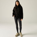 Full-length view of a model wearing the Regatta women's black borg fleece jacket with leggings and walking shoes.