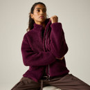 Model wearing the Regatta women's fig borg fleece jacket while seated, showing the high collar and soft borg fabric.