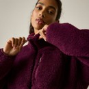 Close-up of a model adjusting the zip on the Regatta women's fig borg fleece jacket with a high collar and zipped chest pocket.