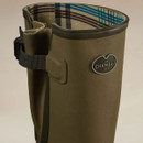Close-up of a Le Chameau green Wellington boot showing the adjustable gusset, buckle strap and checked lining.