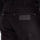 Close-up of the back pocket on Wrangler Greensboro black denim jeans featuring the tonal Wrangler logo patch, matte black rivets and signature W stitching.