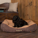 Black dog relaxing in a brown Scruffs Thermal Box Bed with quilted thermal lining and raised padded sides in a cosy home interior.
