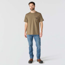 Full-length view of a model wearing a brown Carhartt graphic pocket T-shirt with blue jeans and work boots.