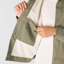 Close-up of the inside of an olive green Carhartt jacket showing the contrasting light lining and large internal patch pocket.