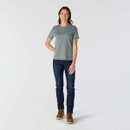 Full-length front view of women’s blue-grey Carhartt pocket T-shirt styled with dark blue jeans and brown work boots.