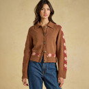 Front view of the brown collared cardigan, styled with jeans to showcase its cropped shape, floral accents and ribbed trims.