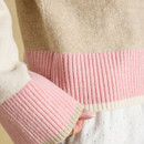 Close-up of the cardigan’s beige knit body and pink ribbed hem and cuff, finished with narrow cream and beige edging.
