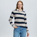 Woman modelling a LeMieux long-sleeve rugby shirt with cream, navy and pink stripes, white collar and LM chest logo, paired with blue jeans.