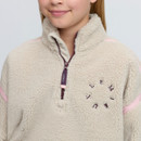 Close-up of the cream LeMieux sherpa fleece showing the textured fabric, high collar, branded quarter zip, embroidered chest logo and pink piping.