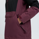 Close-up of the plum side pocket and adjustable cuff on a black and plum LeMieux outdoor jacket.
