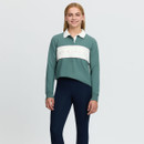 Full-length front view of a young rider wearing a green LeMieux long-sleeve polo top with white collar and logo chest panel, paired with navy riding leggings.