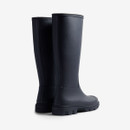 A pair of tall navy rubber boots with a textured sole, viewed from the back.