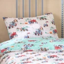 Children’s tractor-print pillowcase and aqua duvet featuring colourful vintage farm vehicles.