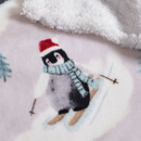A soft throw featuring a penguin in a scarf and hat, on a light background with snowy designs and a fluffy white edge.