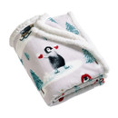 Folded white sherpa fleece Christmas throw featuring colourful penguin and winter tree designs.