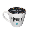 A white ceramic mug with a curved shape and a blue star on the front, featuring a dark interior with gold star patterns.
