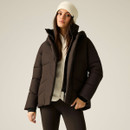 A woman models a brown puffer jacket with a high collar, worn over a light top and black leggings, set against a neutral background.