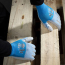 A pair of blue and white gloves resting on wooden planks, featuring a textured grip design.