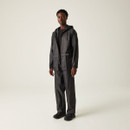 A person stands in a neutral pose wearing a black raincoat and trousers against a light gray background, conveying a minimalist and sleek style.