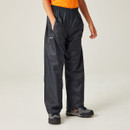 Child wearing navy Regatta Stormbreak waterproof overtrousers with elasticated waist and side pockets, paired with an orange T-shirt and walking shoes.