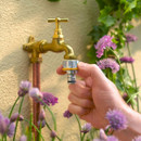 Hozelock Pro Metal Tap Connector being fitted to an outdoor garden tap for a secure hose connection.