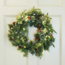 Christmas wreath with lights and red berries on a white door.