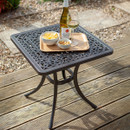 Outdoor table with snacks and a bottle of wine on a sunny deck.