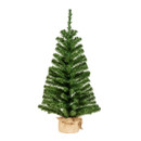 A small, artificial green Christmas tree with burlap wrapping at the base, standing upright against a white background.