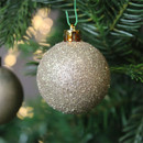 A close up view of the pearl glitter bauble hanging from a Christmas Tree.