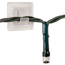 Close-up of a transparent self-adhesive cable clip securing a green Christmas light cable, designed for tidy and reliable mounting of indoor or outdoor string lights on smooth surfaces.