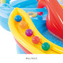 Inflatable ball rails holding colourful plastic balls beside a water play centre slide