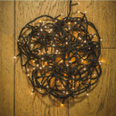 Coiled warm white LED string lights hanging on a wooden surface, demonstrating compact storage and flexible installation options.