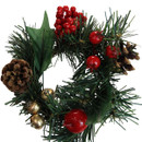 Close-up of a festive Christmas candle ring featuring realistic pine foliage, red berry clusters, pinecones, holly leaves and metallic gold berries.