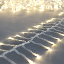 Close-up of warm white LED cluster lights on a transparent wire, showing closely spaced bulbs for a bright and elegant Christmas lighting display.