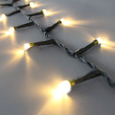 Close-up of warm white LED Christmas lights on discreet green wiring, showcasing soft warm illumination and flexible cable construction.