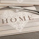 HOME placemat with neutral wood-effect design and decorative heart motif, styled on a dining table with cutlery.