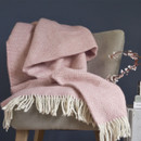 A pink and white blanket on a chair