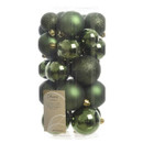Tub of assorted dark green Christmas baubles in mixed glossy, matte and glitter finishes for Christmas tree decorating.