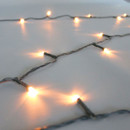 Close-up of antique white LED Christmas lights featuring soft warm-white bulbs on discreet green wiring, highlighting elegant illumination and flexible cable design.