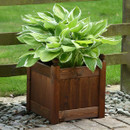 Stained wooden square garden planter with panelled sides beside a fence and stone border.
