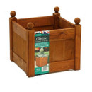 Angled view of stained wooden square planter with panelled sides and ball finial corner posts, on a light background with Classic product label attached.