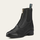 A black leather ankle boot with a front zip and elastic side panels, set against a plain light beige background. The design is classic and sleek.
