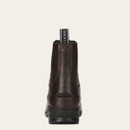 A brown leather ankle boot shown from the back against a light background. It features a pull tab with branding and a sturdy black sole, conveying durability and style.