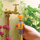 Hozelock garden hose connector attached to an outdoor tap, with a yellow hose connected for easy garden watering.