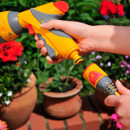 Hozelock AquaStop hose connector in use, allowing a spray gun to be disconnected without turning off the water supply.